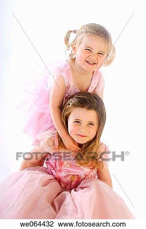 two sisters aged 5 and 3 playing together on the floor of the studio, smiling into camera View Large Photo Image Stock Image - two sisters aged 5 and 3 playing together on the floor of the studio, smiling into camera. Fotosearch