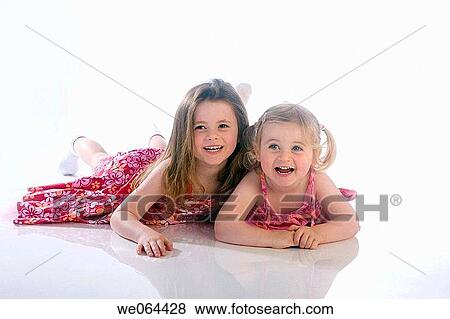 two sisters aged 5 and 3 playing together on the floor of the studio View Large Photo Image Stock Photo - two sisters aged 5 and 3 playing together on the floor of the studio. Fotosearch