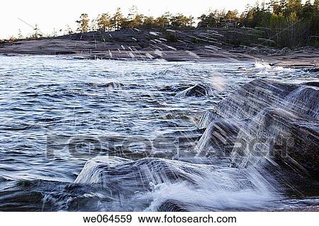Stock Photo - Wave spraying over stones. Rotsidan, H÷ga Kusten, coast of Baltic Sea, V? sternorrlands l? n, Sweden, Scandinavia, Europe. Fotosearch