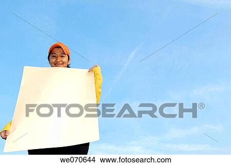 Woman holding a blank poster _ advertisement sign. View Large Photo Image Picture - Woman holding a blank poster _ advertisement sign.. Fotosearch
