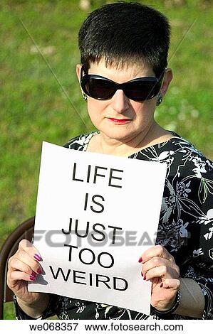 Woman holding a sign reading,? LIFE IS JUST TOO WEIRD? View Large Photo Image Stock Photo - Woman holding a sign reading,? LIFE IS JUST TOO WEIRD?. Fotosearch