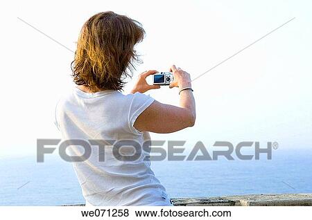 Woman using digital camera above the sea. View Large Photo Image Stock Photo - Woman using digital camera above the sea.. Fotosearch