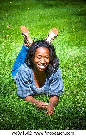 Young black woman lying on the ground, posing View Large Photo Image Stock Image - Young black woman lying on the ground, posing. Fotosearch