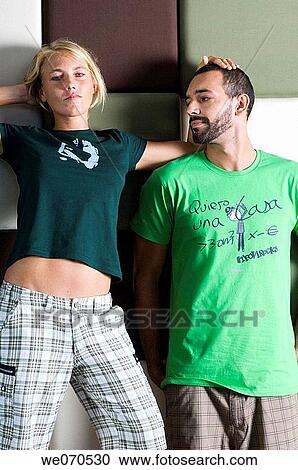 Young couple posing and leaning against the wall View Large Photo Image Stock Image - Young couple posing and leaning against the wall. Fotosearch