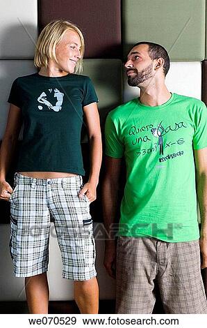 Young couple posing and leaning against the wall View Large Photo Image Stock Photo - Young couple posing and leaning against the wall. Fotosearch