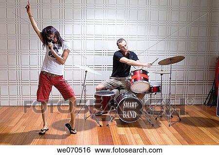 Young couple singing and playing music View Large Photo Image Stock Photograph - Young couple singing and playing music. Fotosearch