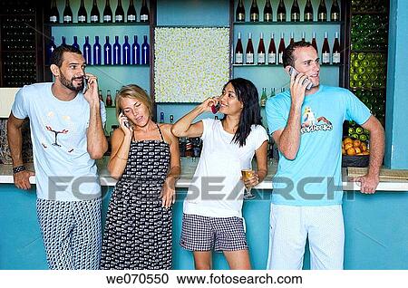 Young couples using cell phone by bar counter View Large Photo Image Stock Image - Young couples using cell phone by bar counter. Fotosearch