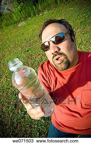 Young heavyset man in his backyard, holding a bottle of water View Large Photo Image Stock Image - Young heavyset man in his backyard, holding a bottle of water. Fotosearch