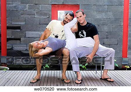 Young woman lying down on two men's lap View Large Photo Image Stock Image - Young woman lying down on two men's lap. Fotosearch