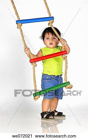 Stock Image - A girl with a rope ladder.. Fotosearch