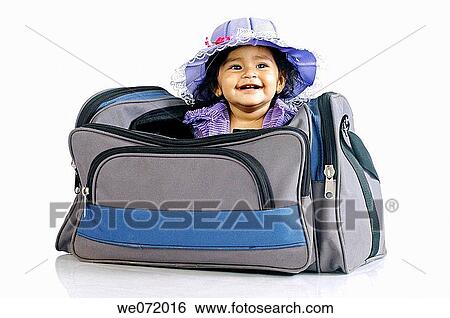 A smiling child sitting in a traveling bag View Large Photo Image Stock Photograph - A smiling child sitting in a traveling bag. Fotosearch