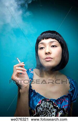Stock Image - addiction, cigarette, Asian, absorbed. Fotosearch