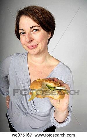 Stock Photo - appetite, burger, brunette, bite, addiction. Fotosearch