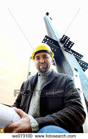 Architect, Engineer, General Contractor with plans on construction site View Large Photo Image Stock Image - Architect, Engineer, General Contractor with plans on construction site. Fotosearch