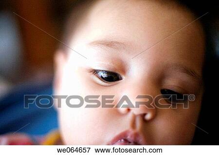 Stock Photo - baby, black hair, Brown eye, child, childhood, Close-up. Fotosearch