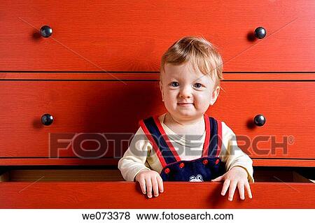 Baby boy playing inside cupboard drawer View Large Photo Image Stock Photo - Baby boy playing inside cupboard drawer. Fotosearch