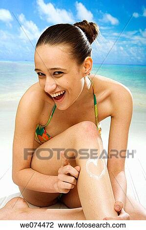Stock Image - beach, brunette, Body care, apply. Fotosearch