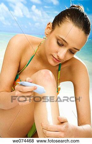 Stock Photo - beach, brunette, Body care, apply. Fotosearch