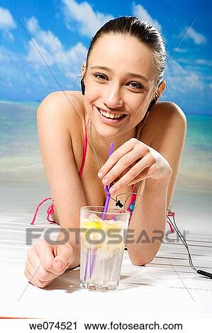Stock Image - beach, brunette, cold drink. Fotosearch