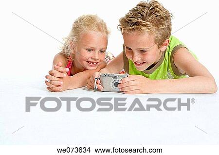 Brother and sister looking at photos in the camera View Large Photo Image Picture - Brother and sister looking at photos in the camera. Fotosearch