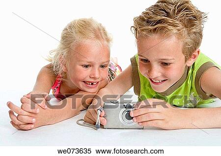 Brother and sister looking at photos in the camera View Large Photo Image Stock Photography - Brother and sister looking at photos in the camera. Fotosearch