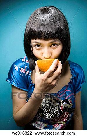 Stock Image - Citrus fruit, eating, contemporary, Asian. Fotosearch