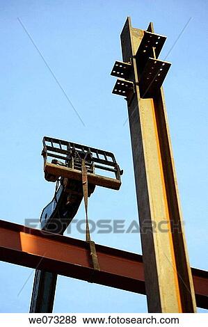 Construction steel I beams being lifted into place with construction lift View Large Photo Image Stock Photo - Construction steel I beams being lifted into place with construction lift. Fotosearch