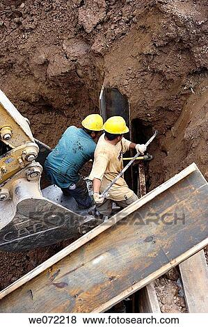 Stock Photo - Construction workers digging out foundation. Fotosearch