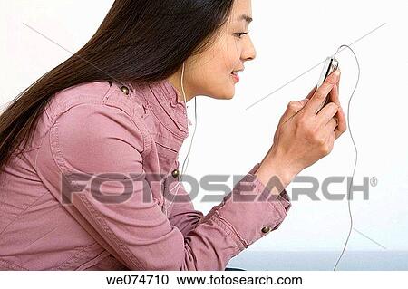 Stock Image - contemporary, ethnic, earphone, Asian. Fotosearch