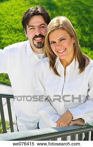 Stock Photography - Couple standing on staircase outdoor, smiling, portrait. Fotosearch