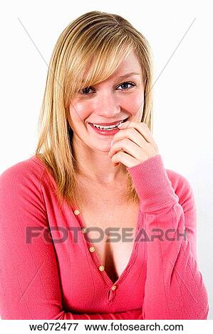 Stock Photo - Cute blond woman flirts with the camera in this studio portrait. Fotosearch