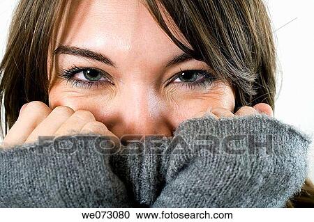 Early 20's caucasian female flirts from behind her sweater in this studio based facial close up portrait. View Large Photo Image Stock Image - Early 20's caucasian female flirts from behind her sweater in this studio based facial close up portrait.. Fotosearch