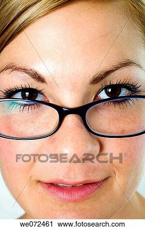 Facial closeup of young blond woman wearing glasses with her hair pulled back in studio. View Large Photo Image Stock Image - Facial closeup of young blond woman wearing glasses with her hair pulled back in studio.. Fotosearch