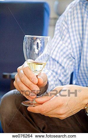 Picture - Friends at a winetasting, holding white wine. Fotosearch