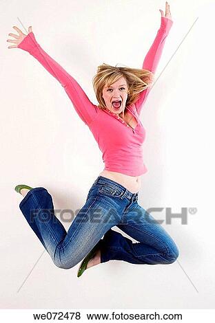 Happy young blond woman jumps for joy in studio portrait. View Large Photo Image Stock Photo - Happy young blond woman jumps for joy in studio portrait.. Fotosearch