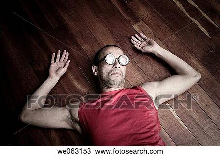 Hispanic man wearing funny round glasses while lying on a wood floor View Large Photo Image Stock Image - Hispanic man wearing funny round glasses while lying on a wood floor. Fotosearch