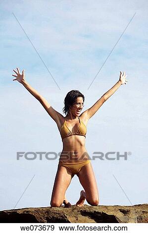 Stock Photo - Latin girl celebrating on the beach. Fotosearch