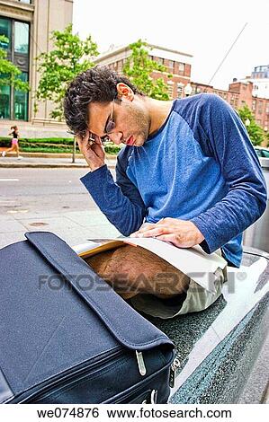 Male college student, wearing glasses, sitting outside next to a city street, studying his notes. View Large Photo Image Stock Photograph - Male college student, wearing glasses, sitting outside next to a city street, studying his notes.. Fotosearch