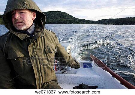 Stock Photo - Man steering a boat with outboard-motor over Gaviksfj? rden, Norastr÷m, V? sternorrlands l? n, Sweden, Scandinavia, Europe. Fotosearch