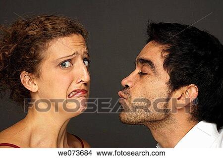 Man tries to kiss woman while she reacts affraid to it View Large Photo Image Picture - Man tries to kiss woman while she reacts affraid to it. Fotosearch