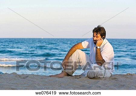 Stock Photo - Man with mobile phone on the beach at sunset, Deerfield Beach, Florida, USA. Fotosearch