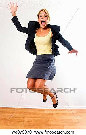 Mid 20's caucasian female in business attire jumps for joy View Large Photo Image Stock Image - Mid 20's caucasian female in business attire jumps for joy. Fotosearch