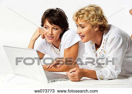 Mother and daughter interact with a notebook computer in a studio setting View Large Photo Image Stock Image - Mother and daughter interact with a notebook computer in a studio setting. Fotosearch