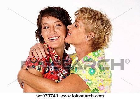 Mother hugs her daughter in a studio setting View Large Photo Image Stock Image - Mother hugs her daughter in a studio setting. Fotosearch
