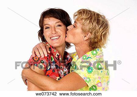 Mother kisses her daughter in a studio setting View Large Photo Image Stock Image - Mother kisses her daughter in a studio setting. Fotosearch