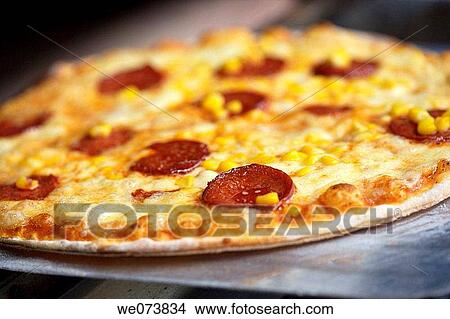 Pepperoni and Corn Pizza getting out of the oven View Large Photo Image Picture - Pepperoni and Corn Pizza getting out of the oven. Fotosearch