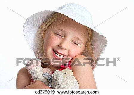 Portrait of a blond girl with a hat and toy animal View Large Photo Image Stock Photo - Portrait of a blond girl with a hat and toy animal. Fotosearch