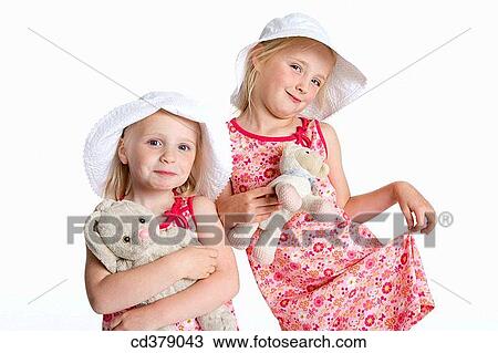 Portrait of two blond girls with hats and their toy animal View Large Photo Image Stock Image - Portrait of two blond girls with hats and their toy animal. Fotosearch