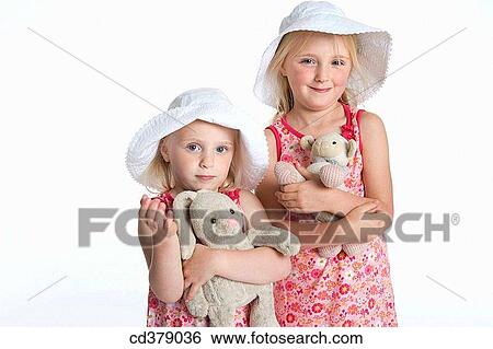 Portrait of two blond girls with hats and their toy animal View Large Photo Image Stock Photograph - Portrait of two blond girls with hats and their toy animal. Fotosearch