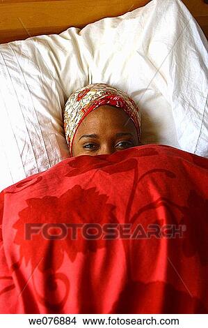 Portrait of woman smiling in bed hiding under comforter View Large Photo Image Picture - Portrait of woman smiling in bed hiding under comforter. Fotosearch